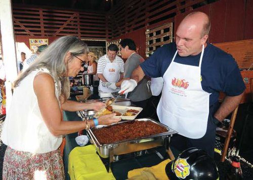 Chief Moller Serves Up The PTA Team's Chili To Connie Bender At The Chili Cook-Off For Wildfire Prevention In 2017 At The Parker Ranch Red Barn. Photo: Laura Ruminski-West Hawaii Today.