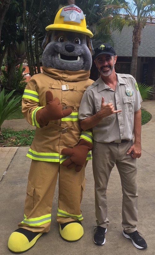 MIKE SHAKAS WITH POKI, HONOLULU FIRE DEPARTMENT’S MASCOT AT THE HONOLULU ZOO DURING FIRE PREVENTION WEEK. PHOTO: MIKE WALKER